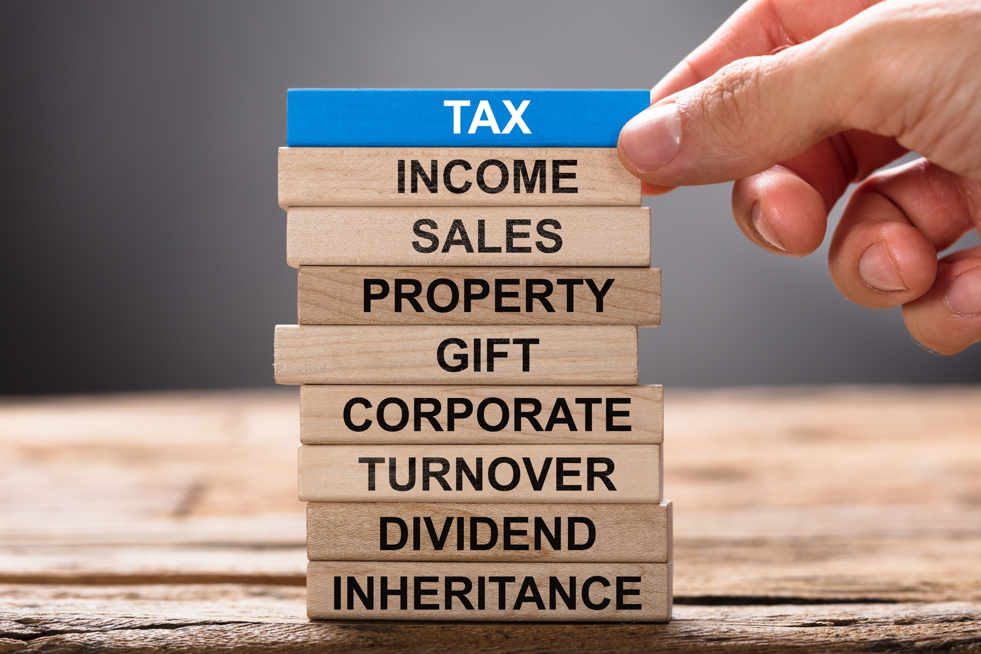 Hand Building Tax Concept With Wooden Blocks